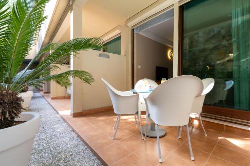 a dining room with white chairs and a table at The Residence Aparthotel in Podstrana