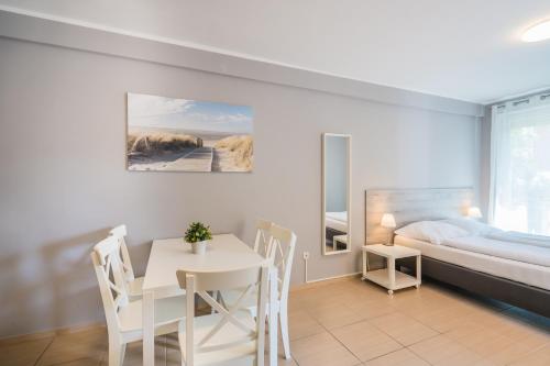 a bedroom with a table and a bed and a table and chairs at Riviéra Apartmanház in Siófok