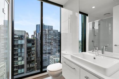 a bathroom with a sink and a toilet and a window at Southbank, River View, Free Parking in Melbourne