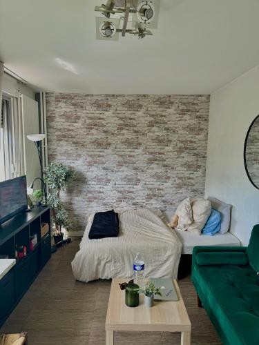 un salon avec un lit et un canapé dans l'établissement Charmant studio à 7min de Paris, à Clichy