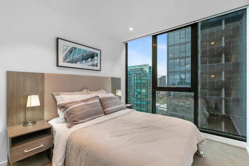 a bedroom with a bed and a large window at Southbank, River View, Free Parking in Melbourne