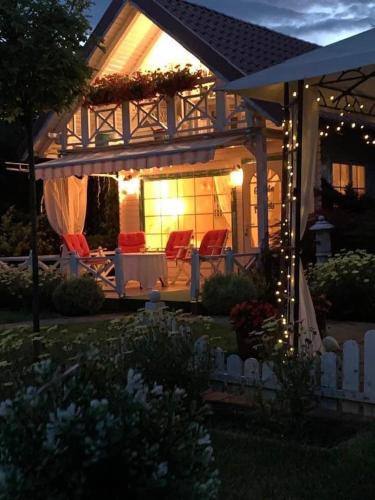 a house with chairs and lights in a yard at Cabana Casuta din Vis in Beclean