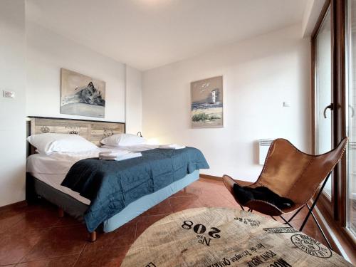 a bedroom with a bed and a chair at Baltic Park Plaza by Baltic Home in Świnoujście