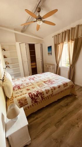 une chambre avec un lit et un ventilateur de plafond dans l'établissement Mazet des Balestiés cœur Luberon 120 m2 6 pers avec piscine, à Gargas