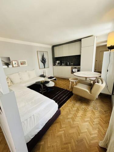 Il comprend un salon avec un grand lit blanc et une cuisine. dans l'établissement Cozy apt Canal Saint Martin, à Paris