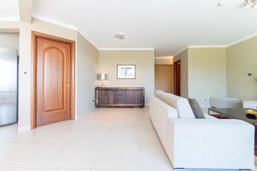 a living room with a white couch and a wooden door at The Residence Aparthotel in Podstrana