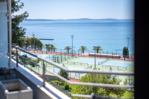 a view of a tennis court and the ocean at The Residence Aparthotel in Podstrana