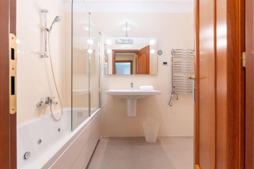 a white bathroom with a sink and a shower at The Residence Aparthotel in Podstrana