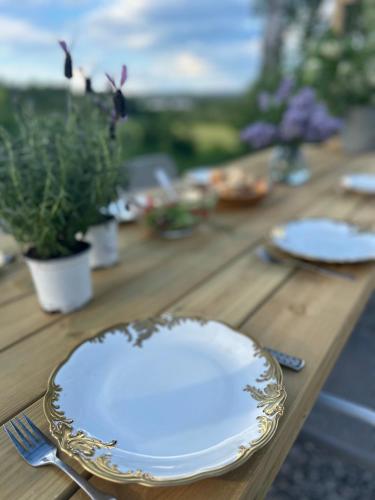 a wooden table with two plates and a fork and knife at Hyra lantligt boende i Höga Kusten in Västhammar
