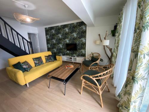 Una sala de estar con un sofá amarillo y una mesa. en Mzelle Pipine, en Saint-Pierre