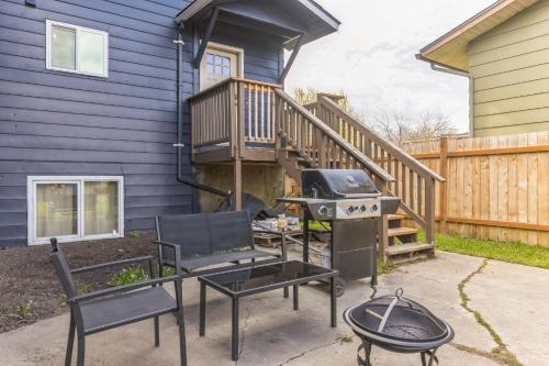 a backyard with a grill and chairs and a house at Apartment in Anchorage -10 Mi to Alaska Zoo! apts in Anchorage