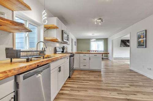 a kitchen with white cabinets and a wooden floor at Apartment in Anchorage -10 Mi to Alaska Zoo! apts in Anchorage