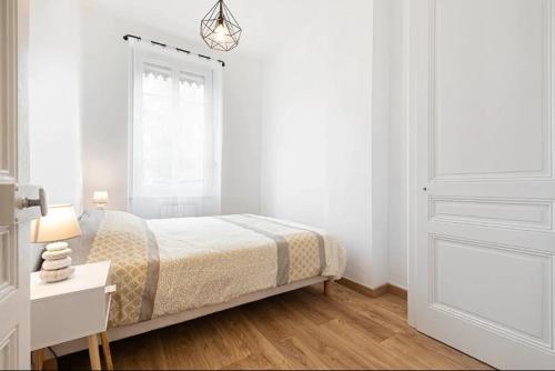 a white bedroom with a bed and a white door at appartement 2 pièces Jean Macé et stationnement in Lyon
