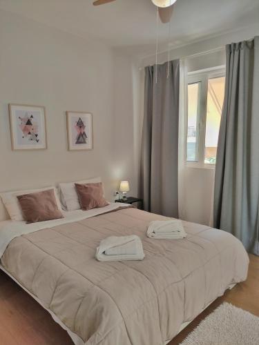 ein Schlafzimmer mit einem großen Bett mit zwei Handtüchern darauf in der Unterkunft Apartment A1 in Kalamata