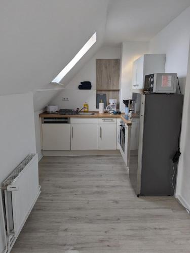 ハイデにある2 Zimmer, Küche, Bad - Monteurszimmer und Dienstwohnung im Boardinghaus Heideの白いキャビネットと黒い冷蔵庫のあるキッチン