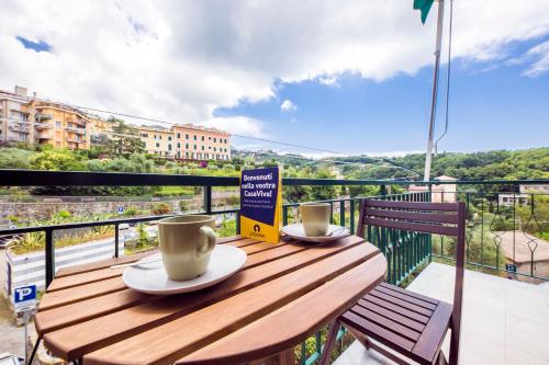 a wooden table with two cups of coffee on a balcony at CasaViva - Quiet Trilo in Camogli in Camogli
