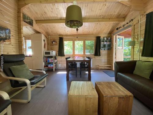 a living room with a couch and a table at Rust en Natuur in Ons Vrijstaande Fins Chalet in Epe