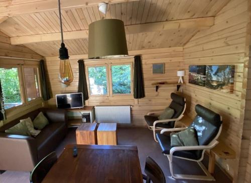 a living room with a couch and a table at Rust en Natuur in Ons Vrijstaande Fins Chalet in Epe