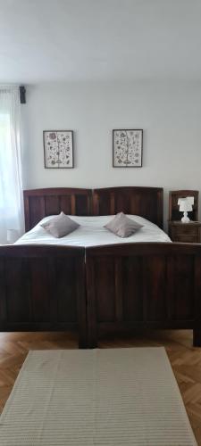 a large bed in a bedroom with two pictures on the wall at Petit Castel in Bran