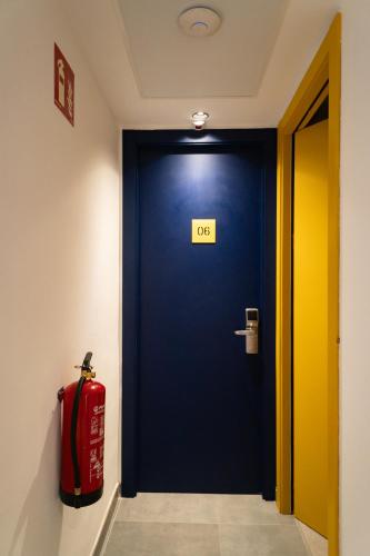 a blue door with a sign on it next to a red suitcase at Sea Hostel Barcelona in Barcelona