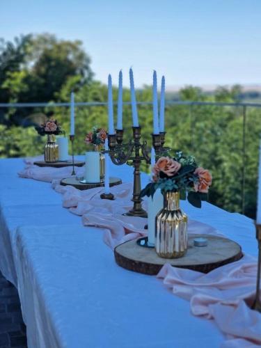 a long table with candles and flowers on it at Vila La hacienda in Beška