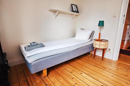 a bed sitting on a wooden floor in a room at HagbackensGård Bed&Breakfast in Örebro