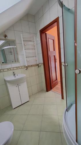 a bathroom with a sink and a red door at Pokoje Gościnne Odargowo Morska 42 in Odargowo