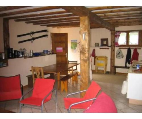 une salle à manger avec des chaises rouges et une table dans l'établissement Chalet - Les 3 vallées, à La Combe