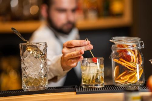 a man holding a drink in a glass jar at Hotel Ramonda in Boljevac