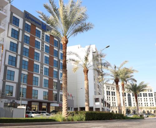 a group of palm trees in front of a building at Kingsgate Canal Hotel by Millennium in Dubai