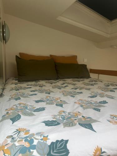 - un lit avec un couvre-lit floral dans l'établissement Le cosy chic 16, à Paris