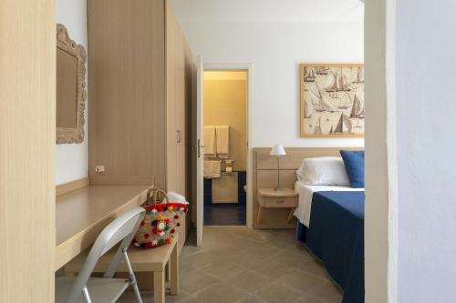 a bedroom with a bed and a desk and a chair at Residence Stella Marina in Ustica