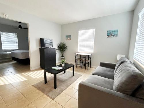 a living room with a couch and a table at Poolfront Cottage Near Beach with Full Kitchen! in Fort Myers
