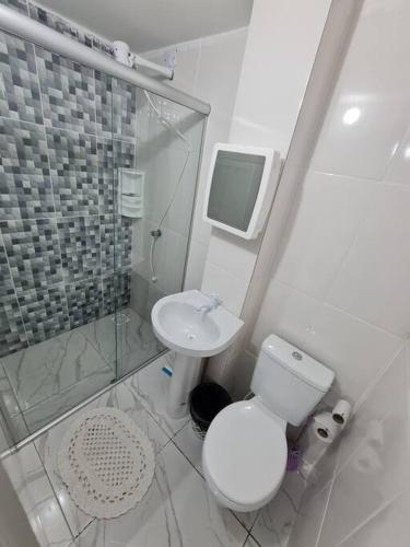 a white bathroom with a toilet and a sink at kitnet 13 central com ar tv smart completa in Montes Claros