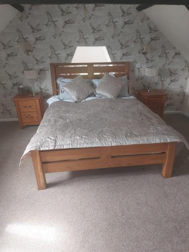 a bedroom with a wooden bed with two pillows at The Blue Bell in Boroughbridge