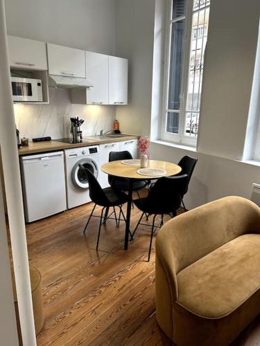 une cuisine avec une table et des chaises dans une pièce dans l'établissement Le Toulousain 002 - Appartement Cosy en Hypercentre - Quartier Jeanne d'Arc, à Toulouse