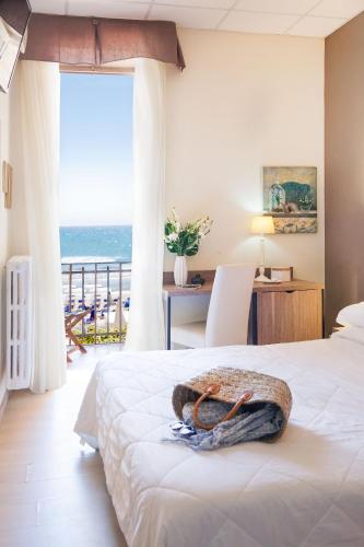 a bedroom with a bed with a view of the ocean at Hotel Tina in Diano Marina