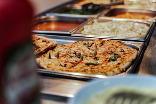 a buffet with several trays of different types of food at MPM Hotel Guinness in Bansko
