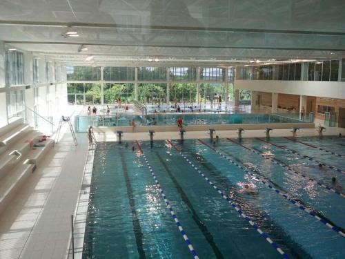 une grande piscine avec de nombreuses personnes dans l'établissement 2 pièces proche Centrex Paris Disney, à Noisy-le-Grand