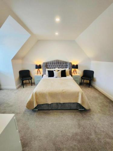 a bedroom with a large bed and two chairs at 3 Bedroom Guest House in Dudley in Dudley