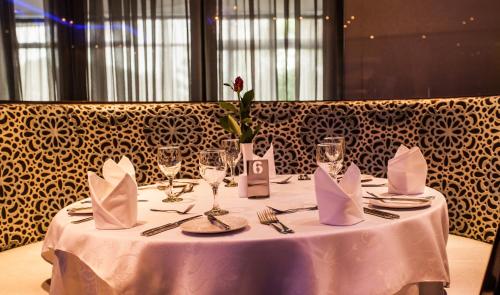 a table with a white table cloth and napkins and wine glasses at Coastlands Musgrave Hotel in Durban