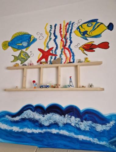 a wall with two shelves with fish on it at Micky e Piero Room in Guidonia