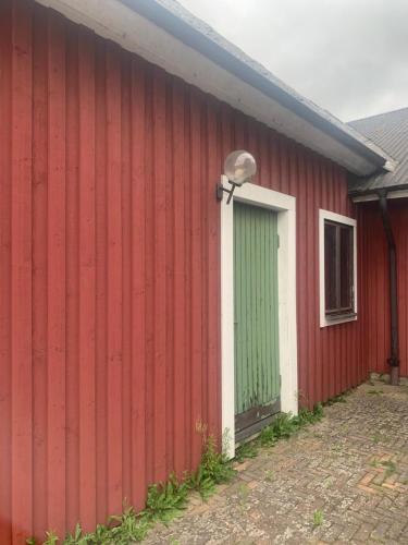 a red and white building with a green door at Fint hus nära Hörby in Hörby