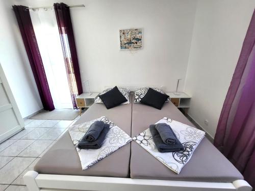 a bed with two pillows on it in a room at Apartments Pitve in Jelsa