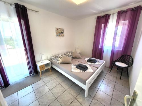 a bedroom with a bed with purple curtains at Apartments Pitve in Jelsa