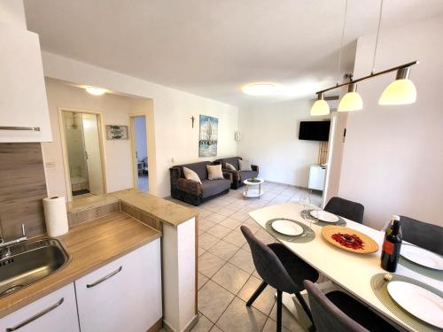 a kitchen and living room with a table and chairs at Apartments Pitve in Jelsa