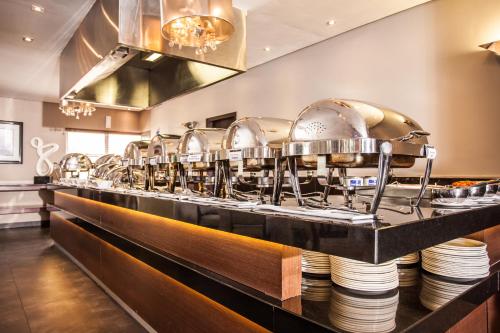 a buffet line with many pots and pans at Coastlands Musgrave Hotel in Durban