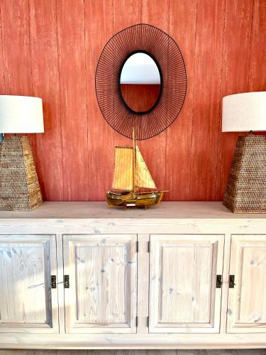 a wooden boat on a cabinet with a mirror at Villa Sudersee in Workum