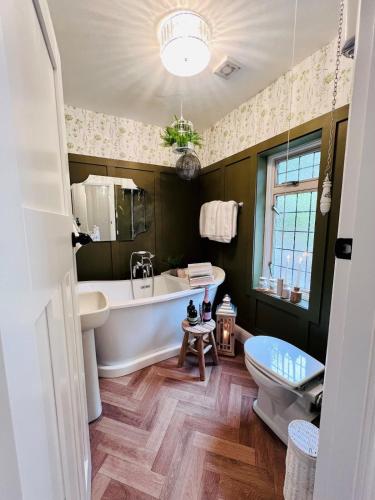 a bathroom with a tub and a sink and a toilet at 5 - Spacious Countryside House for Families & Groups in Pont Sticill