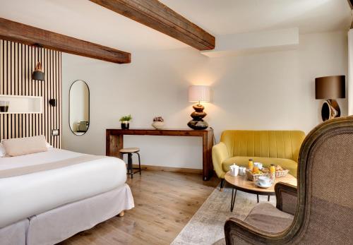 a hotel room with a bed and a chair and a table at R&eacute;sidence des Ducs in Dijon